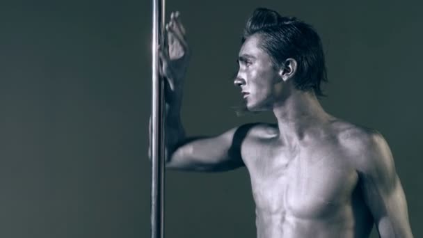 Un type avec une pose d'art corporel argenté au pylône. Mode garçon sur pylône. Concept de danse en nylon . — Video
