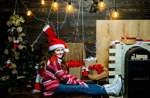 Bílé brusle. Šťastná holčička s vánoční dárek na dřevěné pozadí. Zimní večer doma. Zimní děti. Vánoční Xmas Zimní dovolená concept. Vánoční strom dekorace. — Stock fotografie