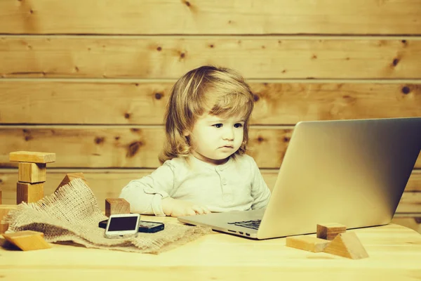 Kleine jongen met computer en telefoon — Stockfoto