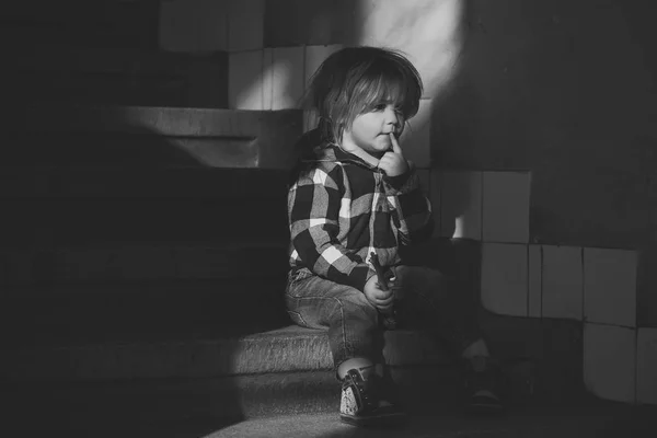 Αγόρι με σκέψης πρόσωπο κάθομαι στις σκάλες του σπιτιού — Φωτογραφία Αρχείου