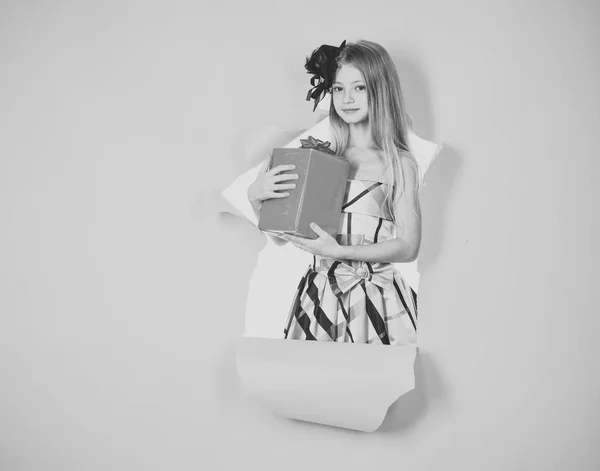 Piccola ragazza caucasica sorridere e tenendo scatola regalo rossa su sfondo rosa. bambino in possesso di scatola regalo — Foto Stock