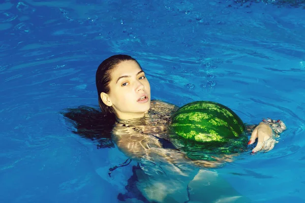 Mujer con sandía en piscina —  Fotos de Stock