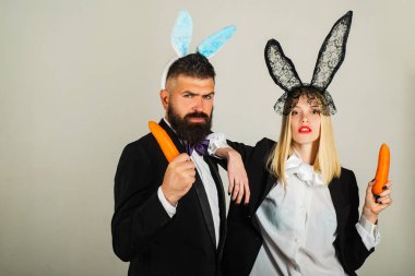 Paskalya havuç ile bir tavşan gibi geldi. Mutlu Paskalyalar. Komik tavşan ve havuç kavramı. Hoş bir çift giyiyor bunny Paskalya gününde.