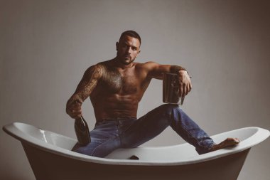 Elit alkol. Lüks elit eğlence. Bir şişe şampanya onun elinde ile çekici bir adam. Acımasız adam alkol ile.