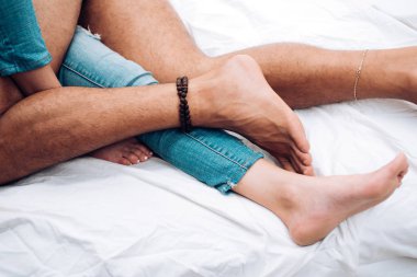 Çift yatakta yatıyor. Aşık oldum. Yatakta bir çift. Tutkulu bir çift öpüşüyor. Seks yapmak. Aşık insanlar. Kadın ve erkek bacakları yatakta. Şehvetli bir sır. Seks ve aşk kavramı.