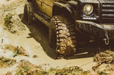 Off-road aracı dağda gider. Yarış yoldan çamur ve su sıçrama içinde. Alt görünümü büyük offroad araba tekerlek üzerinde ülke road ve dağlar zemin için.