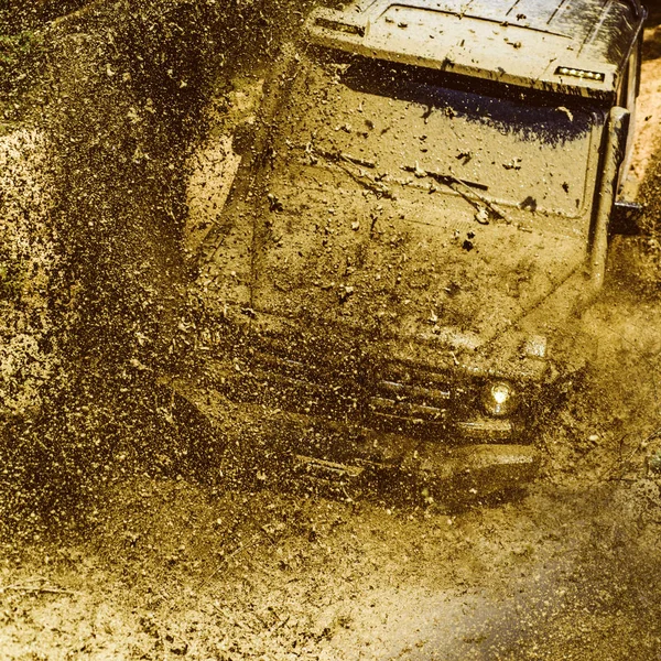 Veículo offroad saindo de um perigo de buraco de lama. Safari suv. Viagem off-road na estrada da montanha. Vestígios num campo lamacento. Mudding é off-roading através de uma área de lama molhada ou argila . — Fotografia de Stock