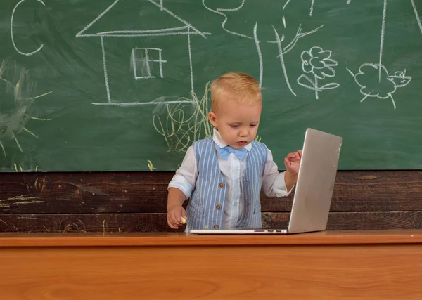 Early development with new technology in primary school. Little boy learn using laptop computer, early development