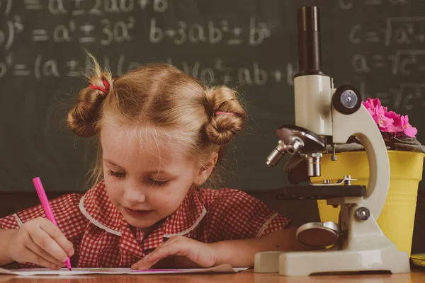 Studentessa lavora alla ricerca di biologia al microscopio. Bambina studia in classe di biologia a scuola, filtro vintage — Foto Stock