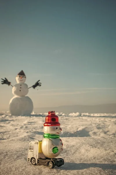Різдвяний сніговик з іграшковим автомобілем у пілотному капелюсі та окулярах — стокове фото