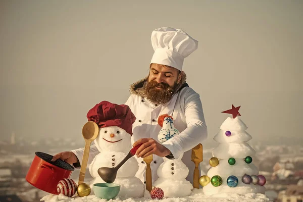 Man in chef hat ladling soup on winter day