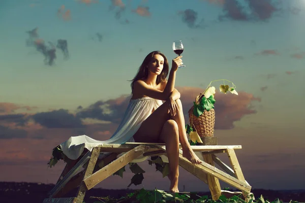 Hübsche Frau mit Wein über dem Himmel — Stockfoto