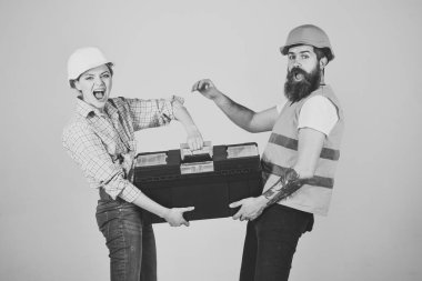 İnşaatçılar toolbox ile aşık çift gri arka plan onarım yapar. Yenileme kavramı. Gülümseyen kadın kask yenileme hakkında heyecan içinde. Tamirci ve araç kutusu tutan kız kopyalama alanı