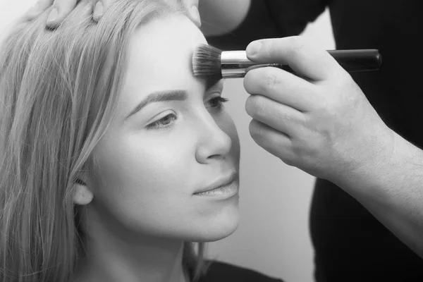 Hand med makeup borste tillämpa pulver på flicka ansikte — Stockfoto