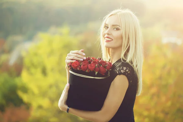 Красивая девушка с цветами в коробке — стоковое фото