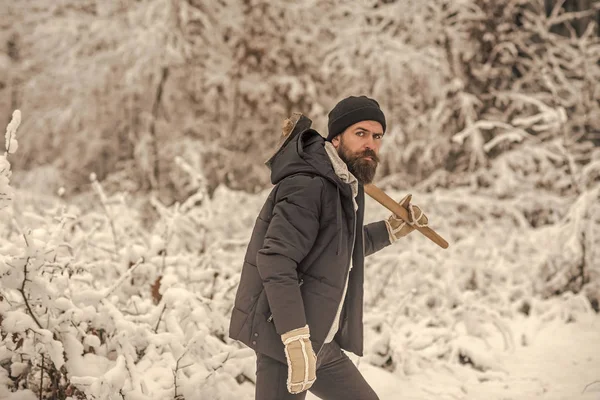 Homem barbudo com machado na floresta nevada . — Fotografia de Stock