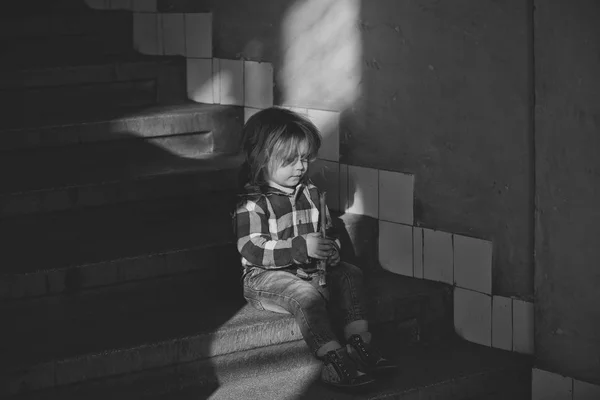 Toddler in blue shirt, jeans, shoes hold stick on staircase — Stock Photo, Image