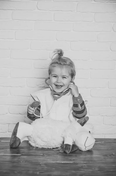 Felice bambino giocare medico con pecore giocattolo sulla parete bianca — Foto Stock