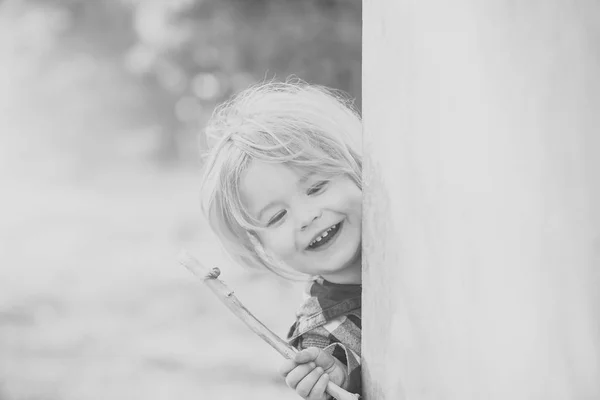 Παιδί με ξανθά μαλλιά χαμόγελο με ραβδί τοίχο γωνία — Φωτογραφία Αρχείου