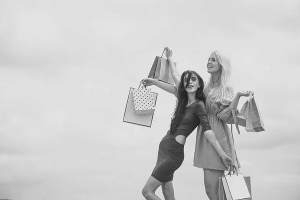 Las mujeres en vestidos de moda tienen bolsas de compras —  Fotos de Stock