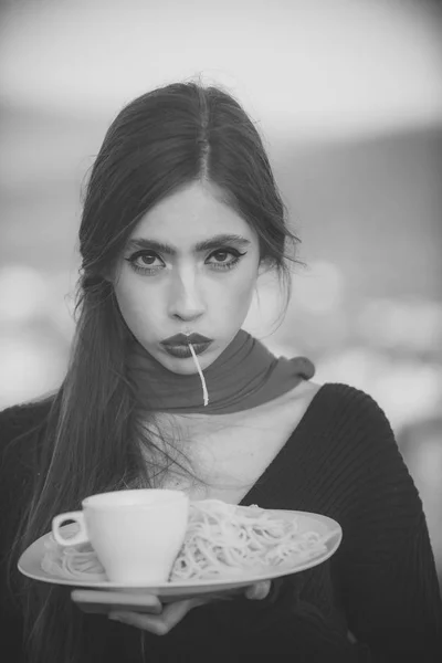 Woman eating pasta as taster or restaurant critic. woman with italian pasta and tea or coffee