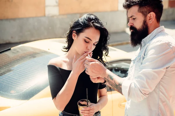 Bad habit and addiction. Romantic couple have cocktail date. Pretty woman and bearded man smoke and drink outdoor. Smoking and alcohol addiction. Couple in love date on street. On the first date