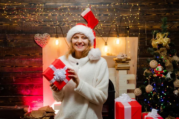 Femme à Santa Hat à la maison. Des émotions cadeaux. Nouvel an. Fille du Nouvel An. Femme avec des boîtes cadeaux de Noël rouges. Femme nouvel an veille. — Photo