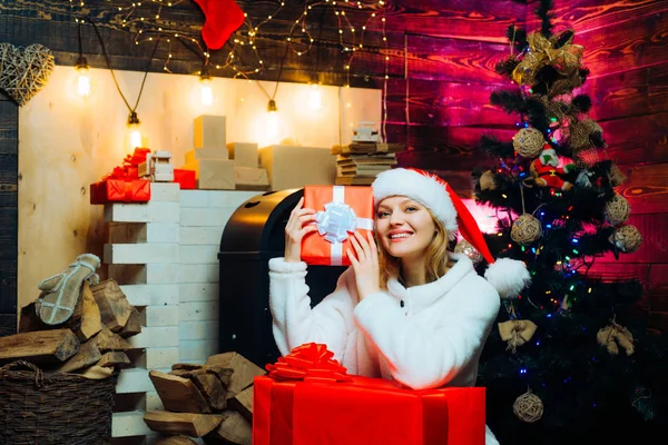 Femme d'hiver portant le chapeau rouge du Père Noël. Joyeux Noël et bonne année. Décorations de Noël et boîte cadeau . — Photo
