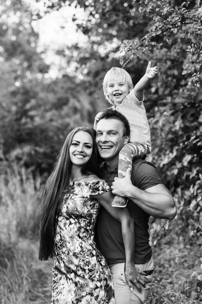 Feliz familia sonriente en el verde parque de verano — Foto de Stock