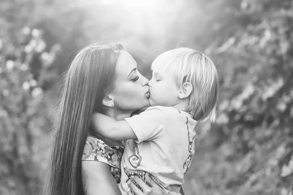 Söta lilla barn kyssas och kramas vackra mor — Stockfoto