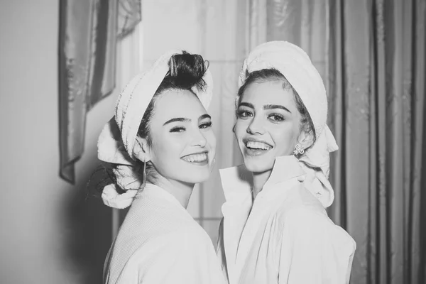 Девушки с полотенцами на головах носят халат с занавесками — стоковое фото