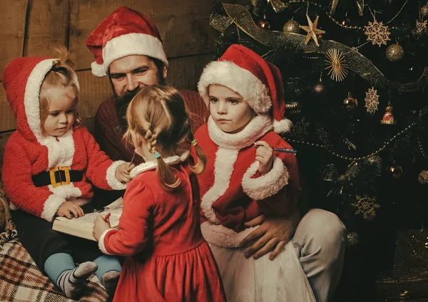 Vánoce šťastné děti a otec četl knihu. — Stock fotografie