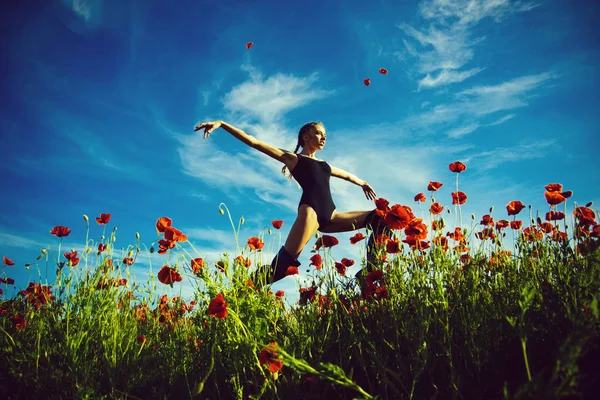 Campo di semi di papavero con donna che salta — Foto Stock