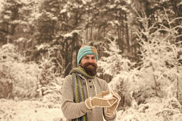 Bebaarde man glimlach met sneeuwbal in het besneeuwde forest — Stockfoto