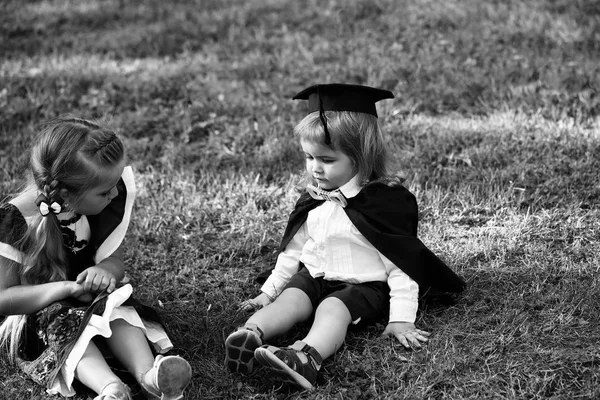 Bonito crianças sentadas na grama verde — Fotografia de Stock