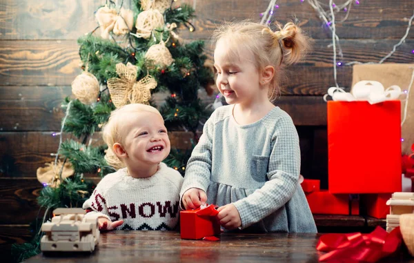 Glückliche Kinder. Babys. Kindergeschenk. Weihnachtsgeschichte. Neujahrskinder. Weihnachtskinder. glückliche kleine Kinder mit Weihnachtsmütze und Geschenk haben ein Weihnachtsfest. — Stockfoto