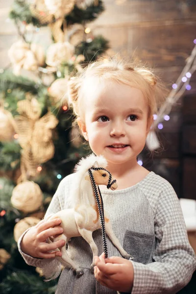 かわいい子女の子は、室内にクリスマス ツリーを飾っています。クリスマスと新年のギフトを開きます。かわいい子供のクリスマスを祝います。お祝いの休日。キディ. — ストック写真