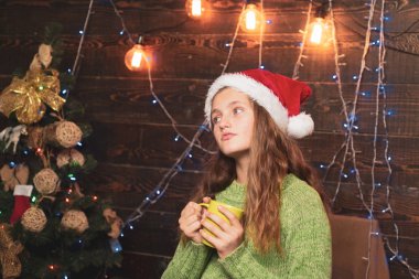 Mutlu küçük kız kış giyim düşünüyorum hakkında Santa Noel ağacının yanında giymiş. Mutlu Noeller ve mutlu yeni yıl. Xmas önce sabah.