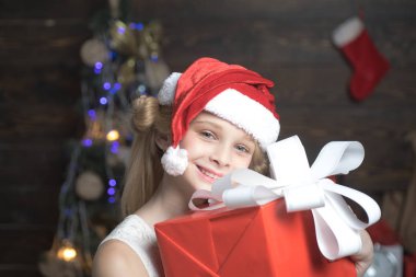 Bir Noel Noel Baba şapkası hediye ile mutlu küçük genç var. Mutlu Noeller ve mutlu tatiller. Çocuk hediye. Kış akşam evde. Yeni yıl çocuklar. Genç yeni yıl.