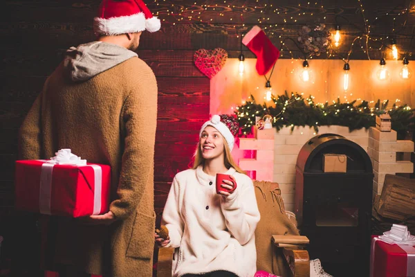 Christmas Modern family i hem. Par i kärlek. Vinter semester och människor koncept. Sensuell tjej till jul. Vackra par klädd i en Santa hatt. Julgran hemma. — Stockfoto