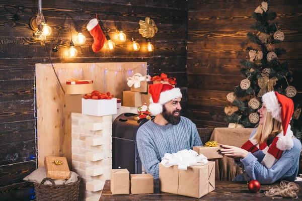 Vackra par klädd i en jultomten hatt. Par i kärlek. Hem julstämning. Julgran dekorera hemma. Julgran hemma. Christmas klänningar. Familj lycka koncept. — Stockfoto