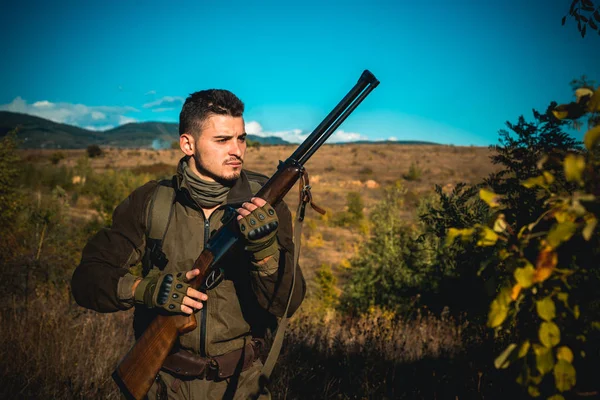 Hunter se déplaçant avec un fusil de chasse à la recherche de proies. Chasseur en vêtements de camouflage prêt à chasser avec fusil de chasse . — Photo