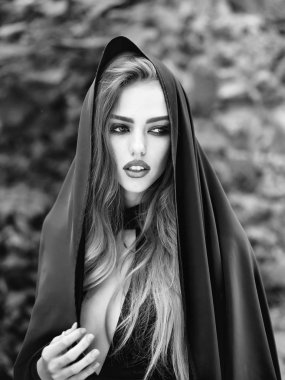 Genç kadın uzun saçlı ve yakışıklı kaputun üstünde baş açık güneşli gün closeup ile seksi Kırmızı elbiseli