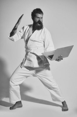 kimono dizüstü bilgisayar ile erkekte karate bağırarak sakallı
