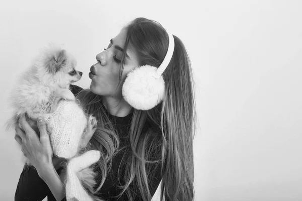 Sexy jolie fille embrasser petit chien poméranien dans des cache-oreilles — Photo