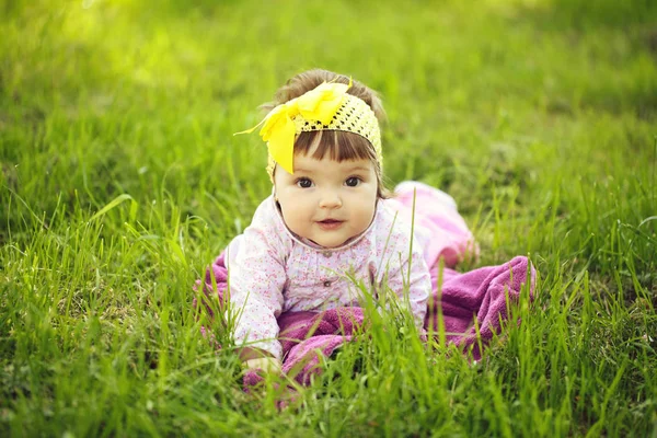 Cute baby girl on green grass — Stock Photo, Image