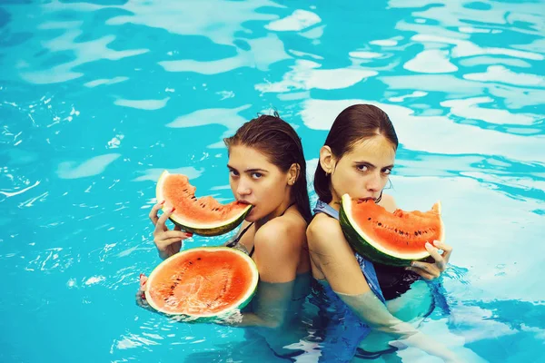Vrouwen met watermeloen in zwembad — Stockfoto