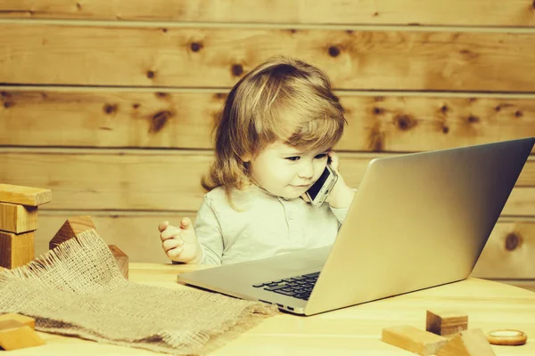 Menino pequeno com computador e telefone — Fotografia de Stock