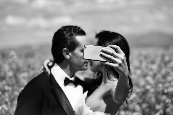 Casamento casal beijo no campo flores amarelas — Fotografia de Stock