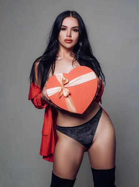 Dia dos Namorados: Presente, Romântico e Data. Belas mulheres sexy modelo menina no amor Dia dos Namorados com um presente de coração vermelho e lábios vermelhos. — Fotografia de Stock